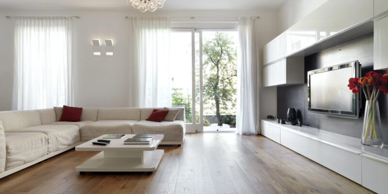 Moderne woonkamer met houten vloer en grote ramen